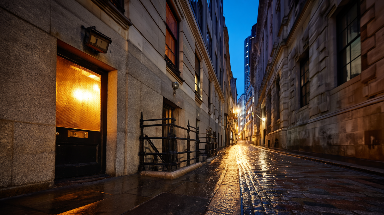 City of London street at night with warm lights glowing from windows